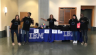 A group of people standing at a table with an IBM display