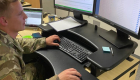 man in military fatigues at a computer