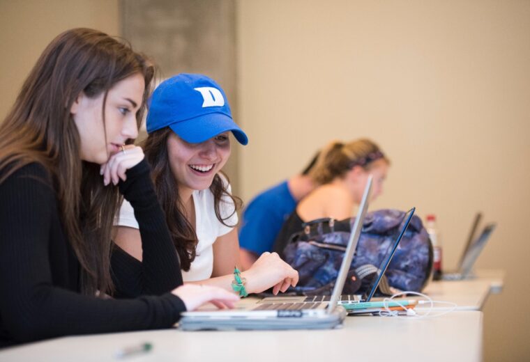 Duke University students look at a laptop computer