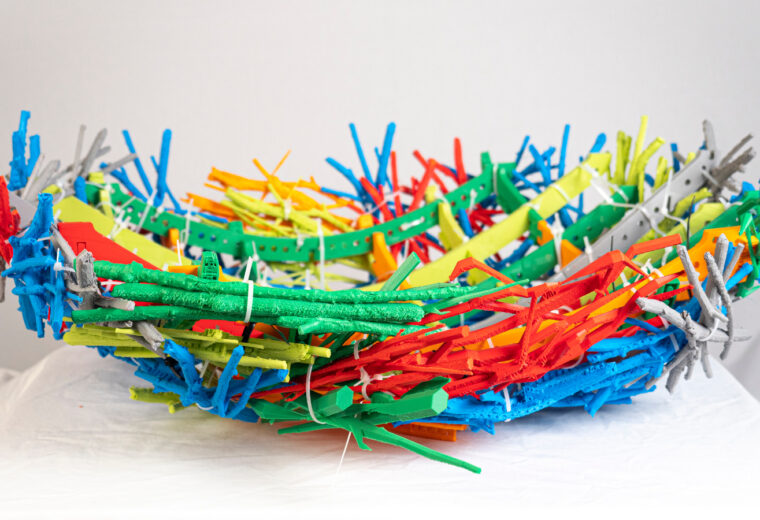 A nest-shaped object with many different colors on a white background