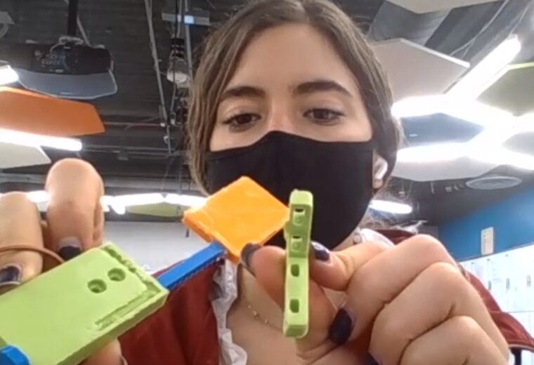 engineering student holds 3D printed items