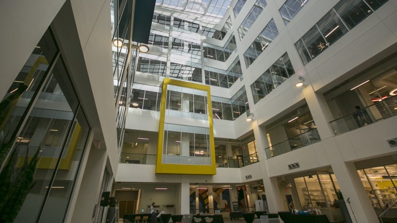 The interior of a building with many levels of hallways extending up to a glass ceiling