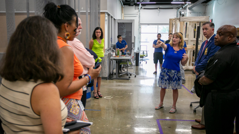 A group of people standing around in a cement-floor research space