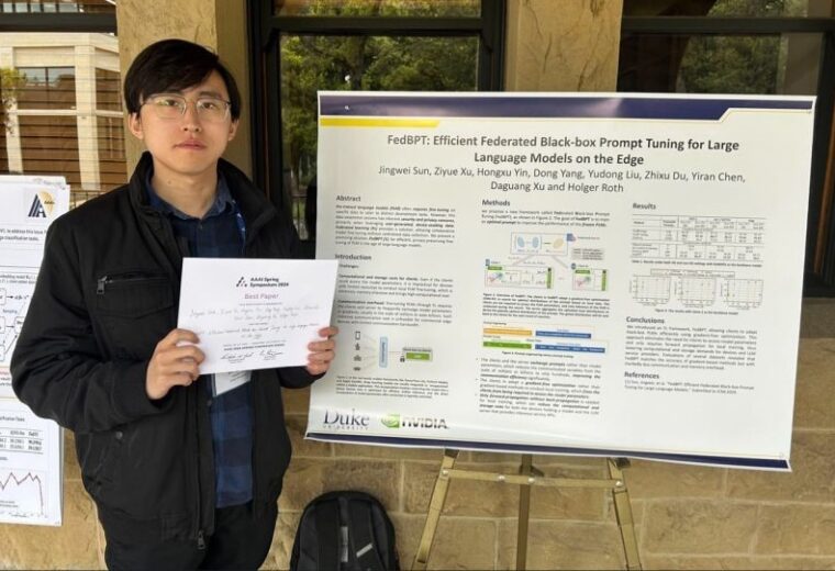 Jingwei Sun stands with research poster