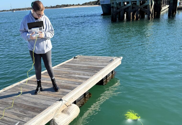 A student observes a hydrophone in the water