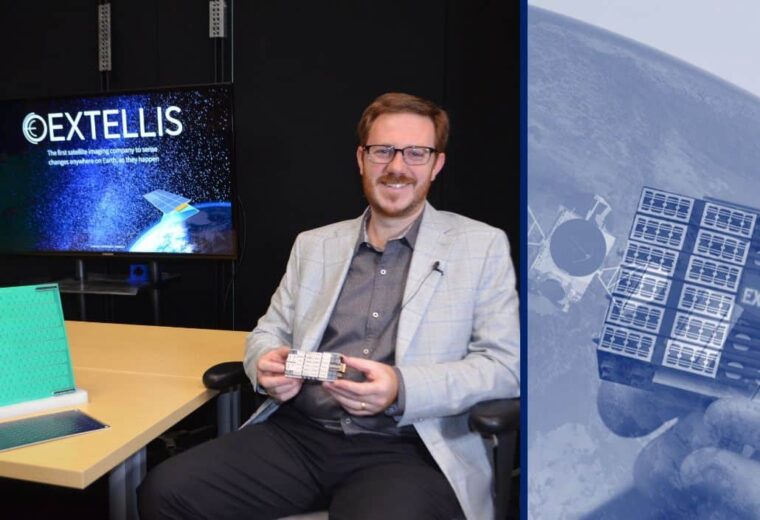 Man sits at table with a green, flat square while holding a small piece of technology